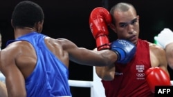 El boxeador venezolano refugiado Eldric Sella, a la derecha, pelea contra un rival dominicano en los Olímpicos de Tokio 2020.