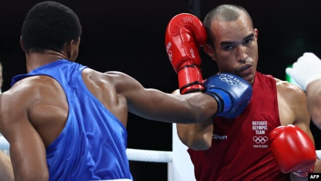 El boxeador venezolano refugiado Eldric Sella, a la derecha, pelea contra un rival dominicano en los Olímpicos de Tokio 2020.