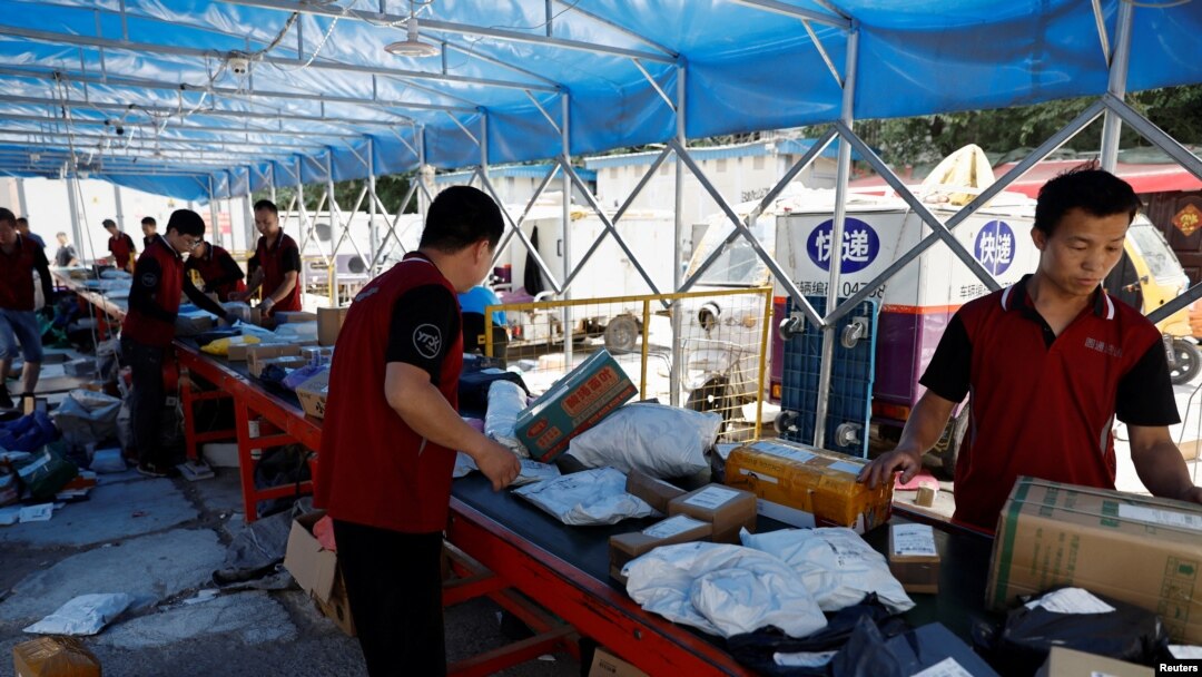 Dostavljači sortiraju pakete na pokretnoj traci, uoči šoping festivala "618", na logističkoj stanici u Pekingu, 12. juna 2023.