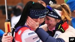 FILE — Joanne Reid, left, of the U.S , and compatriot Deedra Irwin embrace at the finish line during the women's 4 x 6 km relay race at the biathlon World Cup in Anterselva, Italy, Jan. 22, 2022. In 2019, with Irwin's support, Reid reported the abuse.