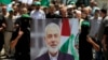 Anggota Hamas memegang poster kepala politik Hamas Ismail Haniyeh yang terbunuh dalam aksi protes di kamp pengungsi Palestina al-Bass, di kota pelabuhan selatan Tyre, Lebanon, Rabu, 31 Juli 2024. (Mohammed Zaatari/AP)