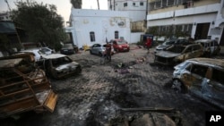 Palestinians check the site of the explosion at Ahli Arab Hospital, in Gaza City, Oct. 18, 2023.