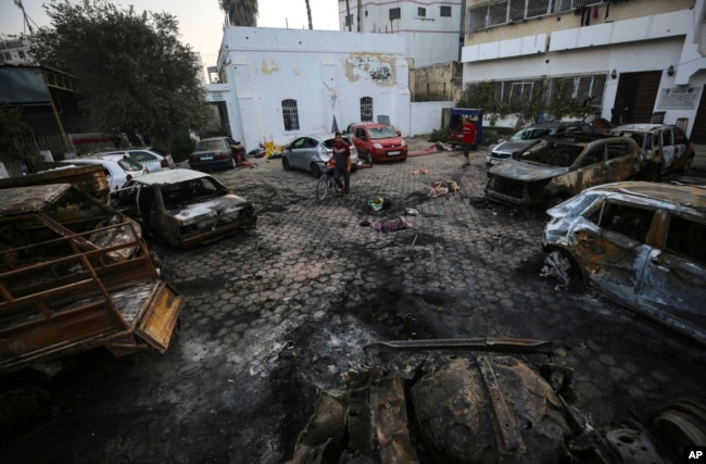 FILE - Palestinians check the place of the explosion at al-Ahli hospital, in Gaza City, Oct. 18, 2023. The Hamas-run Health Ministry says an Israeli airstrike caused the explosion, but the Israeli military says it was a misfired Palestinian rocket. (AP Photo/Abed Khaled)