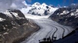 FILE - People enjoy the view at the Aletsch Glacier near Goms, Switzerland, on June 14, 2023. Swiss glaciers have lost 10% of their volume since 2021, and some glaciers are predicted to disappear entirely in the next few years.