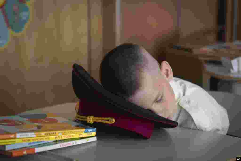 A young cadet takes a nap at the first lesson in a cadet lyceum on the first day at school in Kyiv, Ukraine.&nbsp;Children and students went to school despite the fact that Kyiv was hit by massive Russian missile barrage early in the morning, causing fires, damaged buildings and infrastructure objects.&nbsp;