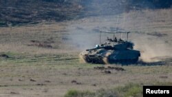 Israeli soldiers operate a tank near Gaza, after a temporary truce between Israel and the Palestinian Islamist group Hamas expired, as seen from southern Israel, December 2, 2023.