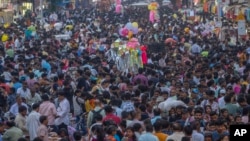 FILE — People crowd a market as they shop ahead of Diwali festival in Mumbai, Nov. 5, 2023. The world population grew by 75 million people over the past year, according to figures released by the U.S. Census Bureau.