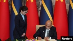 Waziri wa Mambo ya Nje wa Nauru Lionel Aingimea akisaini waraka wa kurejesha uhusiano wa kidiplomasia kati ya Jamhuri ya Nauru, na China huko Beijing, Jan 24, 2024