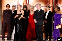 FILE - Producer Emma Thomas, foreground left, accepting the award for best motion picture drama for "Oppenheimer" as others look on during the 81st Annual Golden Globe Awards in Beverly Hills, Calif., on Sunday, Jan. 7, 2024. (Sonja Flemming/CBS via AP)