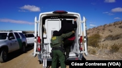 Agentes de la Patrulla Fronteriza suben a un vehículo a un migrante hondureño detenido después de cruzar irregularmente a Estados Unidos hacia Sunland Park, Nuevo México, desde Ciudad Juárez, México, el 26 de enero de 2024.