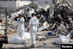 以色列救援人员南部的斯德罗特市一个被哈马斯武装分子炸毁的警察局废墟里寻找死难者。（2023年10月11日）