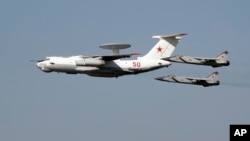 FILE - In this Aug. 11, 2007 photo, an A-50, the Russian equivalent of the American AWACS aircraft based on the Ilyushin Il-76 freighter, NATO reporting name: Mainstay, flies escorted by MiG-31 interceptor jets, over Monino, Russia. 