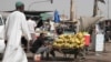 FILE - Seorang pria menjual pisang di pasar selama gencatan senjata di Khartoum, Sudan, 27 Mei 2023. Dua badan PBB memperingatkan meningkatnya keadaan darurat pangan termasuk kelaparan di Sudan, di Haiti, Burkina Faso, dan Mali.