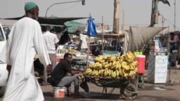 FILE - Seorang pria menjual pisang di pasar selama gencatan senjata di Khartoum, Sudan, 27 Mei 2023. Dua badan PBB memperingatkan meningkatnya keadaan darurat pangan termasuk kelaparan di Sudan, di Haiti, Burkina Faso, dan Mali.