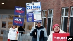 Sejumlah pendukung calon presiden AS berkumpul di luar sebuah tempat pemungutan suara dalam pemilihan pendahuluan di Windham, New Hampshire, 23 Januari 2024. (Foto: Michael Dwyer/AP Photo)