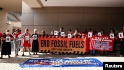 Aktivis iklim melakukan protes untuk menyerukan dihentikannya penggunaan bahan bakar fosil, selama Konferensi Perubahan Iklim PBB COP28 di Dubai, Uni Emirat Arab, Minggu 10 Desember 2023.