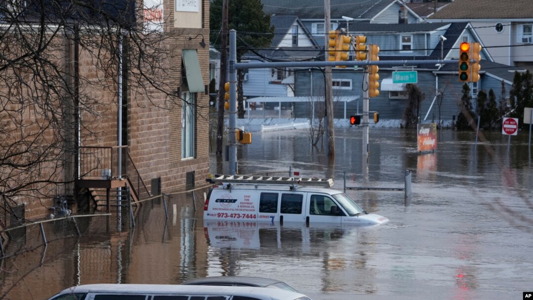 Sejumlah kendaraan tampak terendam banjir yang melanda area dekat sungai Saddle di Lodi, New Jersey, pada 10 Januari 2024. (Foto: AP/Seth Wenig)