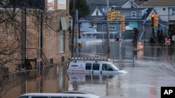 Sejumlah kendaraan tampak terendam banjir yang melanda area dekat sungai Saddle di Lodi, New Jersey, pada 10 Januari 2024. (Foto: AP/Seth Wenig)