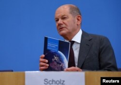 Kanselir Jerman Olaf Scholz memegang dokumen selama konferensi pers di House of 'Bundespressekonferenz' di Berlin, Jerman, 14 Juni 2023. (Foto: Reuters)