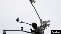 一名男子在上海街头的多个监控摄像头下看手机。（2023年9月27日）