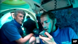 FILE - Submersible pilot Randy Holt, right, and Stockton Rush, left, CEO and Co-Founder of OceanGate, dive in the company's submersible, "Antipodes," about three miles off the coast of Fort Lauderdale, Fla., June 28, 2013.