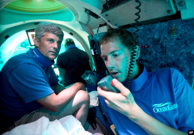 ARCHIVO: El piloto sumergible Randy Holt, a la derecha, y Stockton Rush, a la izquierda, director ejecutivo y cofundador de OceanGate, se sumergen en el sumergible de la compañía, "Antípodas", a unas tres millas de la costa de Fort Lauderdale, Florida, el 28 de junio de 2013. .