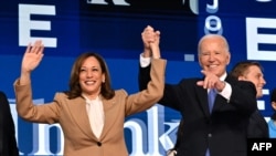 Presiden AS Joe Biden memegang tangan Wakil Presiden AS sekaligus calon presiden Demokrat 2024 Kamala Harris setelah menyampaikan pidato utama pada hari pertama Konvensi Nasional Demokrat (DNC) di United Center di Chicago, Illinois, 19 Agustus 2024. (Robyn Beck / AFP)