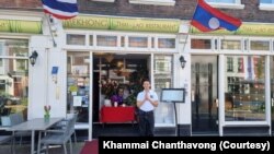 ທ່ານຄໍາໄມ ຈັນທະວົງ, ເຈົ້າຂອງຮ້ານອາຫານ 'Mekhong Thai-Lao Restaurant' ຢືນຖ່າຍຮູບຕໍ່ໜ້າຮ້ານອາຫານຂອງຕົນ, ຢູ່ເມືອງເດລ, ປະເທດເນເທີແລນ.
