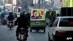 A poster of Sheikh Rasheed Ahmad, election candidate of Pakistan's Awami Muslim League party, is displayed behind an auto-rickshaw in Rawalpindi on Jan. 3, 2024.