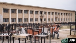 FILE - A worker rests at a construction site for the "Jeux de la Francophonie 2023," in Kinshasa, Democratic Republic of Congo, on July 20, 2023.