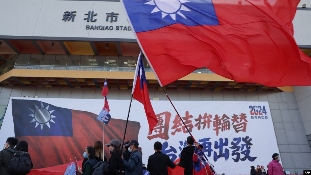 Sejumlah orang mengibarkan bendera Taiwan selama kampanye partai oposisi utama Kuomintang (KMT) menjelang pemilihan presiden, di New Taipei City pada 12 Januari 2024. (Foto: AFP)