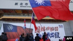 Sejumlah orang mengibarkan bendera Taiwan selama kampanye partai oposisi utama Kuomintang (KMT) menjelang pemilihan presiden, di New Taipei City pada 12 Januari 2024. (Foto: AFP)