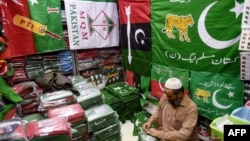 A shopkeeper arranges flags of political parties at his shop ahead of the upcoming general elections in Karachi on Jan. 3, 2024.