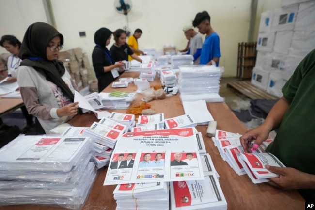 Para pekerja melipat surat suara untuk pemilu presiden saat persiapan distribusi logistik pemilu di Tangerang, 10 Januari 2024. (Foto: AP)