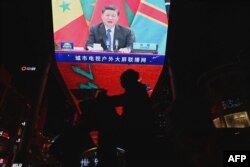 FILE - Presiden China Xi Jinping terlihat di layar lebar di sebuah mal di Beijing, pada upacara pembukaan Forum Kerja Sama China-Afrika (FOCAC) ke-8, 30 November 2021.