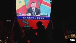 FILE - China's President Xi Jinping is pictured on a big screen during an evening news program showing Xi's keynote speech at the opening ceremony of the 8th Forum on China-Africa Cooperation at a mall in Beijing, Nov. 30, 2021. 