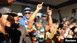 Former boxing champion Floyd Mayweather gestures to fans upon his arrival at Robert Gabriel Mugabe International Airport in Harare, Zimbabwe, July 13, 2023.
