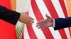 资料片：美国总统拜登与中国国家主席习近平在印度尼西亚巴厘岛20国集团峰会期间举行面对面会谈前伸手握手。（2022年11月14日）