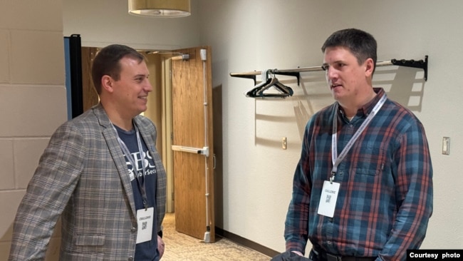 FILE - Jon Waldman, left, co-owner of SBS CyberSecurity spoke with Bill Voecks, chief information officer at Reliabank in Watertown, S.D. on March 22, 2024. (Bart Pfankuch / South Dakota News Watch)