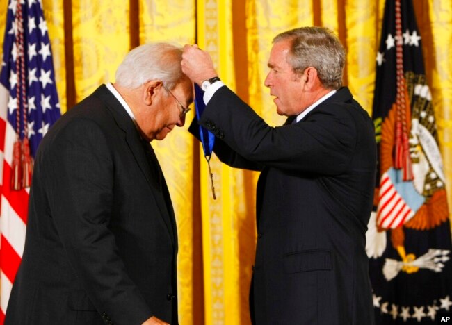 FILE - President George W. Bush, right, presents the 2007 National Medal of Arts to author N. Scott Momaday, during a ceremony in the East Room of the White House, Nov. 15, 2007.