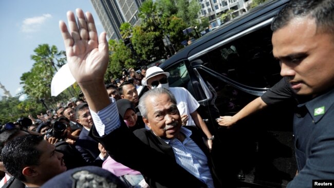 FILE - Former Malaysian Prime Minister Muhyiddin Yassin waves outside Kuala Lumpur Court Complex in Kuala Lumpur, March 10, 2023.