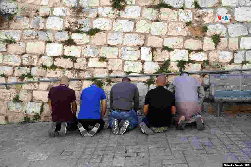 Varios palestinos rezan en la calle durante la oración del viernes, pues la policía de fronteras de Israel ha restringido los accesos a la Explanada de las Mezquitas, principal punto de concentración de la población musulmana de Jerusalén para la oración del viernes.