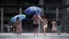 在热浪中，香港儿童在一处喷泉戏水乘凉。(2023年7月9日)
