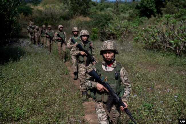 FILE - Members of the Mandalay Peoples Defense Forces patrol near the front line amid clashes with Myanmar's military in northern Shan state, Dec. 10, 2023.