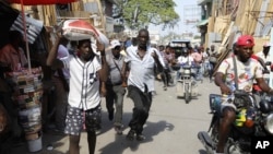 FILE - Pedestrians run for cover after hearing gunshots in Port-au-Prince, Haiti, March 7, 2024.