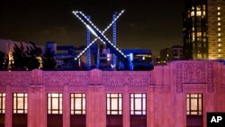 Workers install lighting on an "X" sign atop the headquarters of the company formerly known as Twitter in San Francisco, July 28, 2023. Days after the unpermitted structure was installed, it was taken down after the city received complaints regarding its safety and illumination.