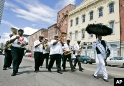 FILE - A New Orleans jazz band marches through the historic French Quarter signaling the start of the Great French Market Creole Tomato Festival, June 13, 2008, in New Orleans.