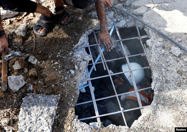 Palestinians search for casualties at the site of an Israeli strike on a house, amid the ongoing conflict between Israel and Palestinian Islamist group Hamas, in Khan Younis in the southern Gaza Strip on November 6, 2023. (REUTERS/Ibraheem Abu Mustafa)