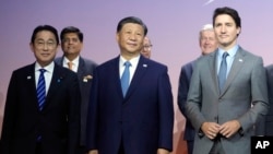2023年11月16日，在旧金山举行的亚太经合组织峰会上，日本首相岸田文雄（左）、中国国家主席习近平（中）和加拿大总理特鲁多（右)合影留影。（美联社）