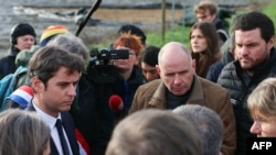 French Prime Minister Gabriel Attal (L) speaks with farmers as he arrives for a visit at a farm in Parcay-Meslay, near Tours, on Jan. 28, 2024, amid nationwide protests called by several farmers unions on pay, tax and regulations.